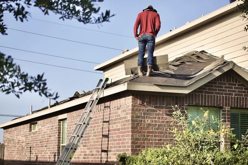 Professional roofer working on a residential roof in Schirm Farm